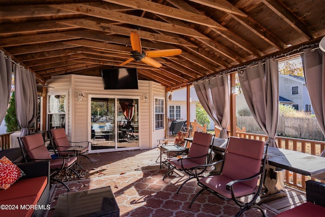 unfurnished sunroom featuring ceiling fan and vaulted ceiling