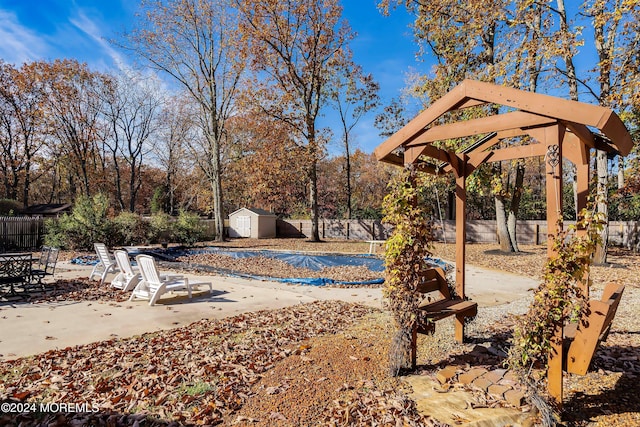 exterior space with a patio area, a storage unit, and a pool