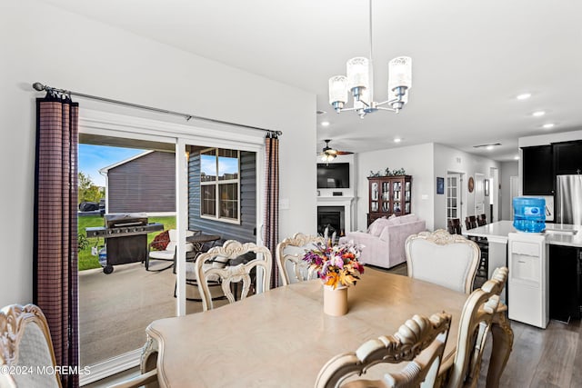 dining room with hardwood / wood-style flooring and ceiling fan with notable chandelier