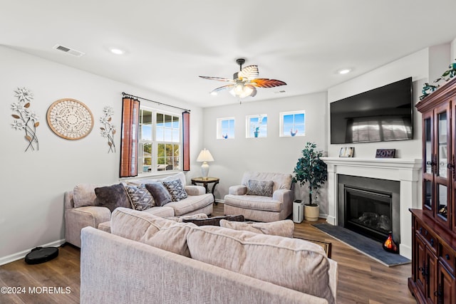 living room with dark wood-type flooring and ceiling fan