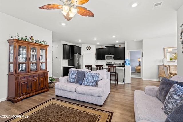 living room featuring light hardwood / wood-style flooring and ceiling fan