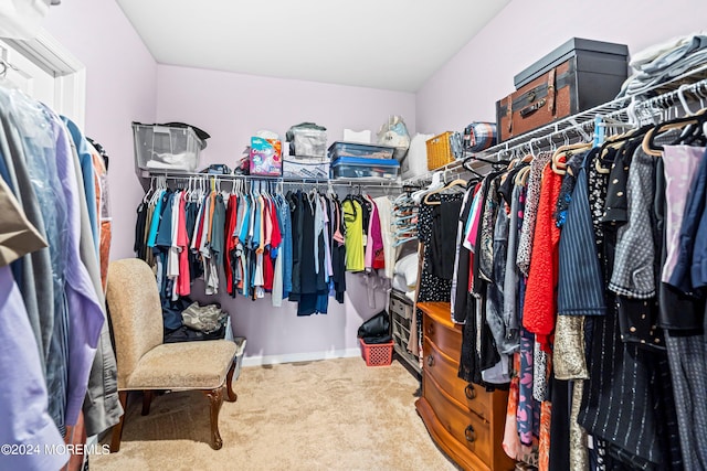 spacious closet featuring light colored carpet