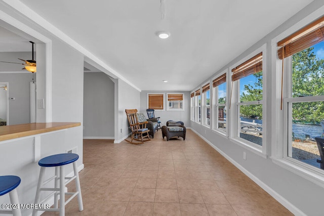 sunroom featuring ceiling fan