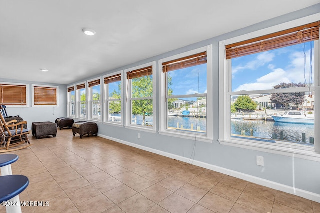 unfurnished sunroom featuring a healthy amount of sunlight and a water view