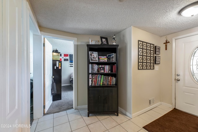 foyer featuring a textured ceiling and light tile patterned floors