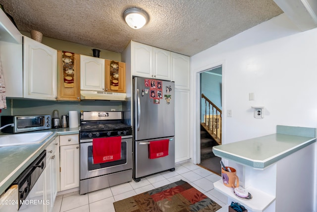 kitchen with white cabinetry, sink, appliances with stainless steel finishes, light tile patterned floors, and a textured ceiling