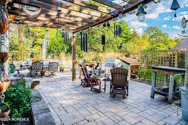 view of patio with area for grilling, a pergola, and outdoor dining space