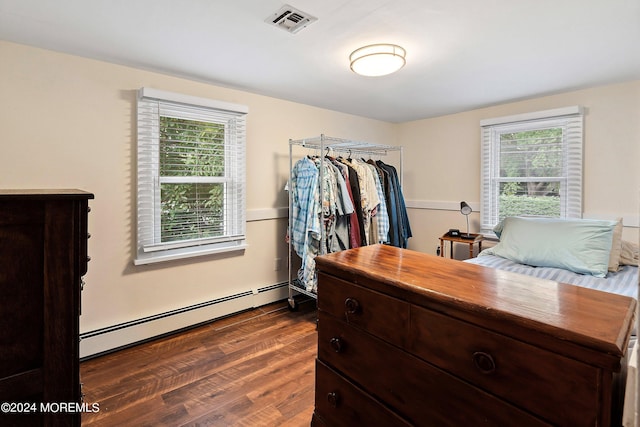 bedroom featuring a baseboard radiator, visible vents, and dark wood finished floors