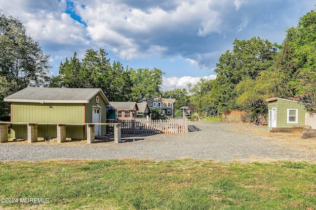 view of play area with a yard, fence, and an outdoor structure