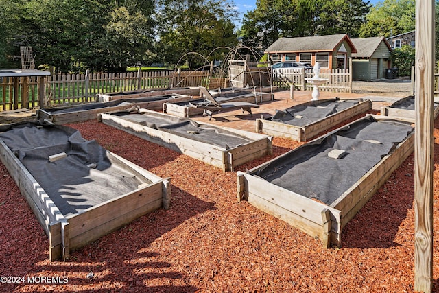 view of yard with an outdoor structure, fence, and a garden