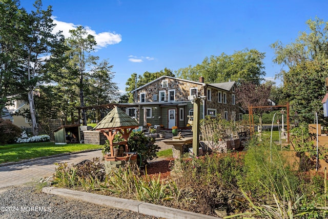 view of front of home featuring decorative driveway and a chimney