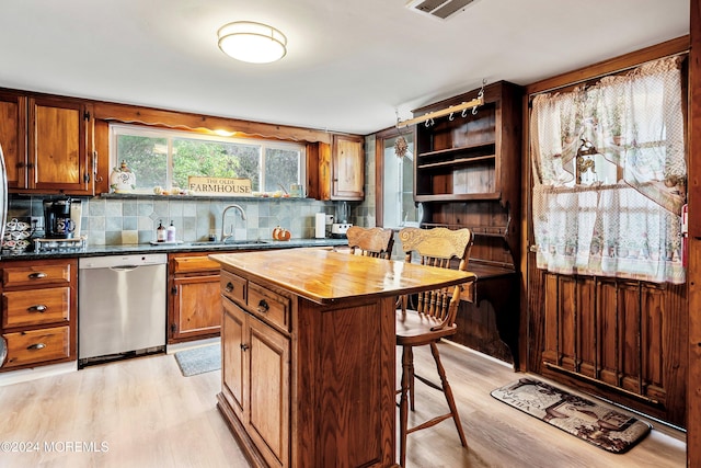 kitchen with a sink, light wood-type flooring, wood counters, and stainless steel dishwasher