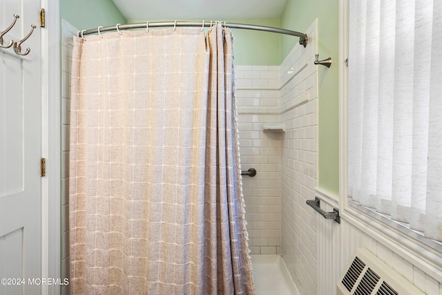 full bath with a shower with curtain and radiator