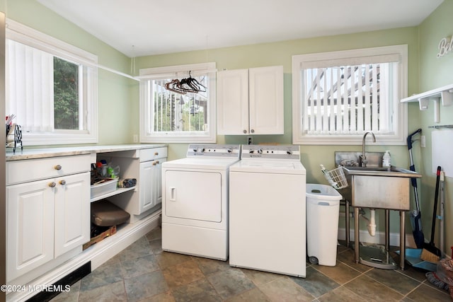 laundry room featuring a sink, washing machine and clothes dryer, cabinet space, and a healthy amount of sunlight