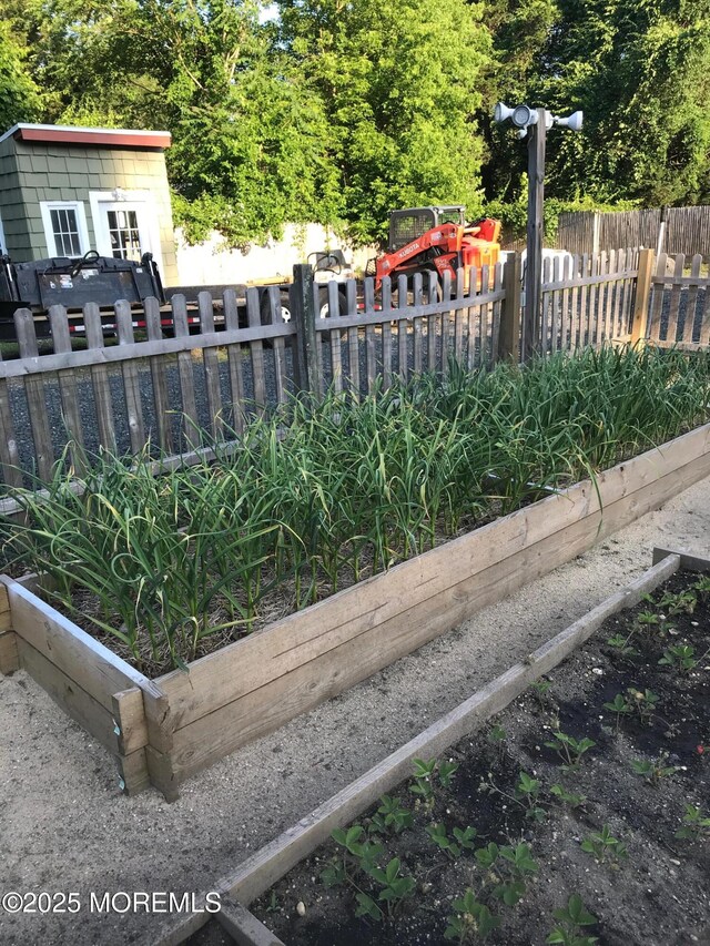 exterior space featuring a vegetable garden and fence