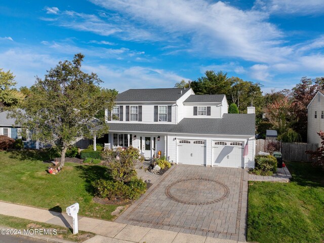 46 Markwood Dr, Howell, NJ 07731 - traditional-style home with a chimney, a porch, fence, decorative driveway, and a front lawn