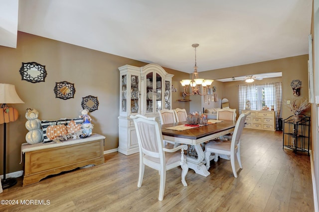 dining space featuring ceiling fan with notable chandelier and light hardwood / wood-style flooring