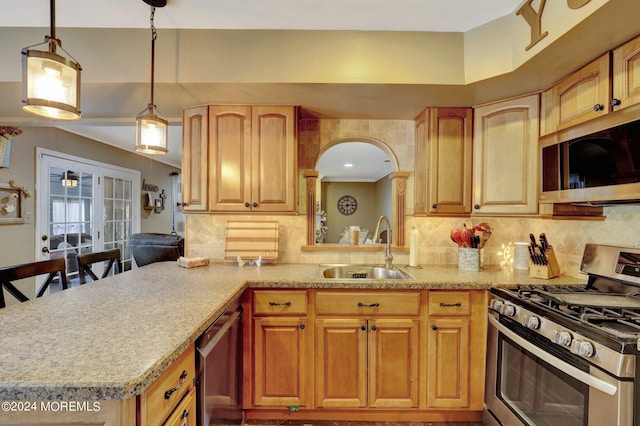 kitchen with sink, a breakfast bar area, decorative light fixtures, stainless steel appliances, and backsplash