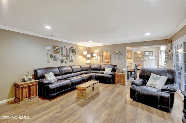 living room with crown molding and light hardwood / wood-style floors