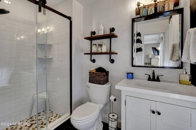 bathroom featuring vanity, an enclosed shower, and toilet