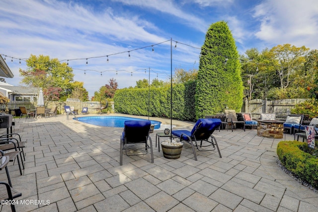 view of swimming pool featuring a patio area and a fire pit