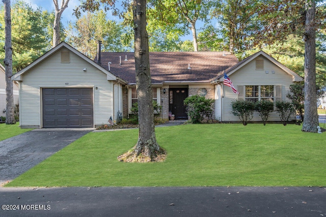 single story home featuring a garage and a front lawn