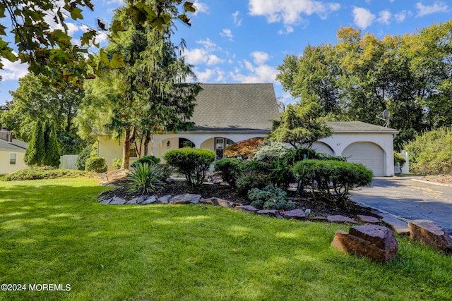 view of front of property featuring a front yard and a garage