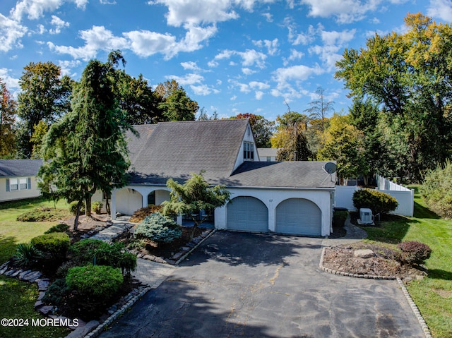 view of front of property with a garage and a front lawn