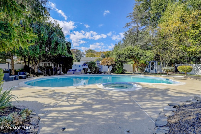 view of pool featuring an in ground hot tub, a diving board, and a patio area