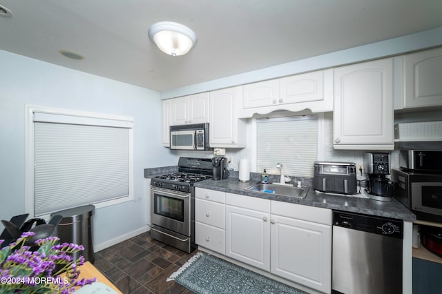 kitchen featuring appliances with stainless steel finishes, sink, and white cabinetry