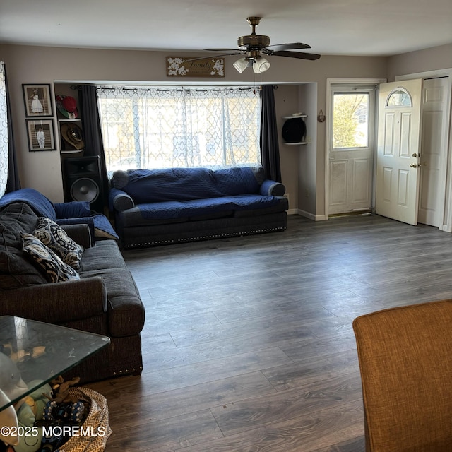 living room featuring dark wood-type flooring and ceiling fan