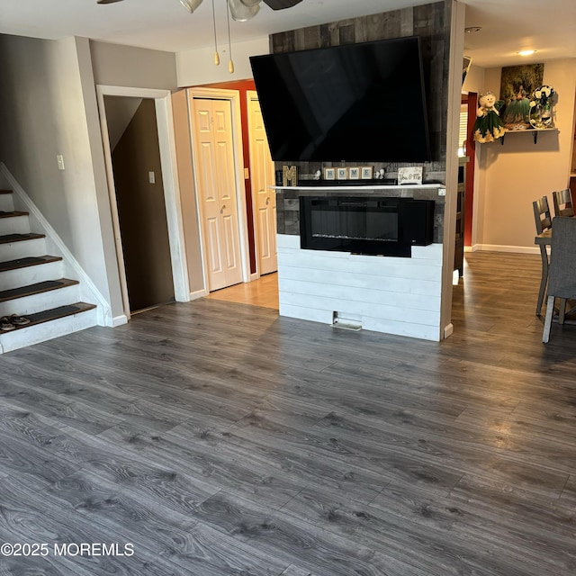 unfurnished living room featuring ceiling fan and hardwood / wood-style floors