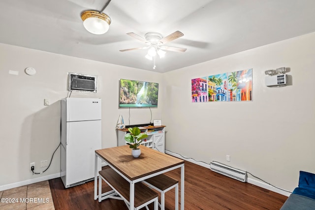 dining room featuring a wall mounted AC, dark hardwood / wood-style floors, ceiling fan, and a baseboard radiator