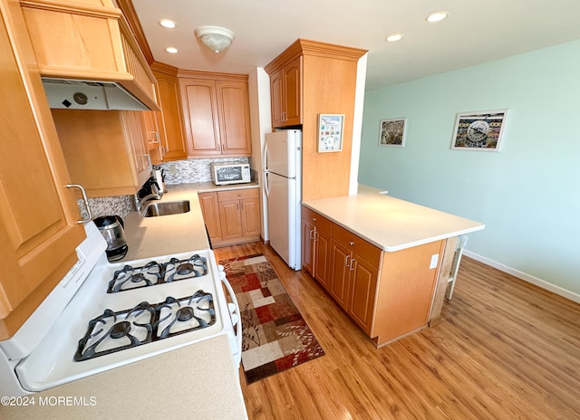 kitchen featuring sink, light hardwood / wood-style flooring, white appliances, backsplash, and premium range hood