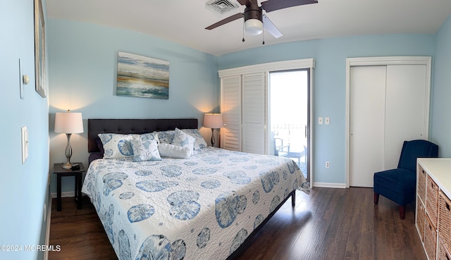 bedroom with ceiling fan, two closets, and dark hardwood / wood-style floors