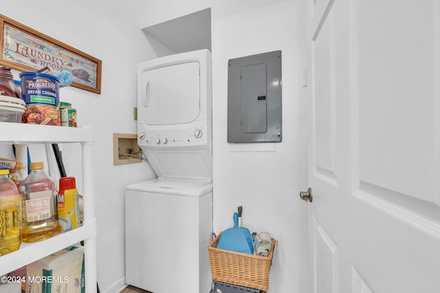 clothes washing area featuring stacked washer and clothes dryer and electric panel