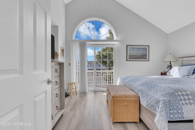 bedroom with access to outside, high vaulted ceiling, and light wood-type flooring