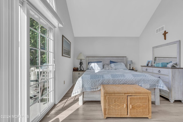 bedroom featuring high vaulted ceiling and light hardwood / wood-style flooring