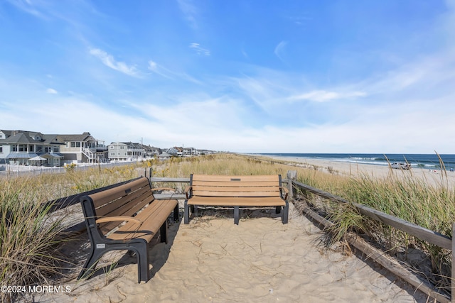 surrounding community with a water view and a beach view