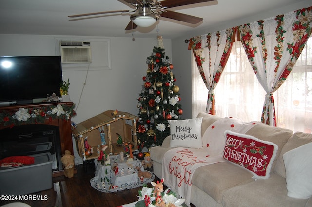 living room with hardwood / wood-style flooring, ceiling fan, and a wall unit AC