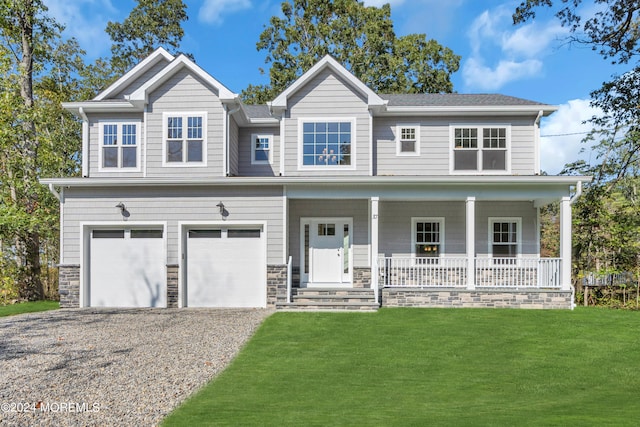 view of front of house featuring a front yard, a porch, and a garage