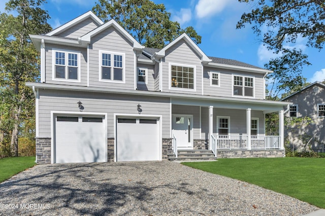 view of front of house with a front lawn, covered porch, and a garage