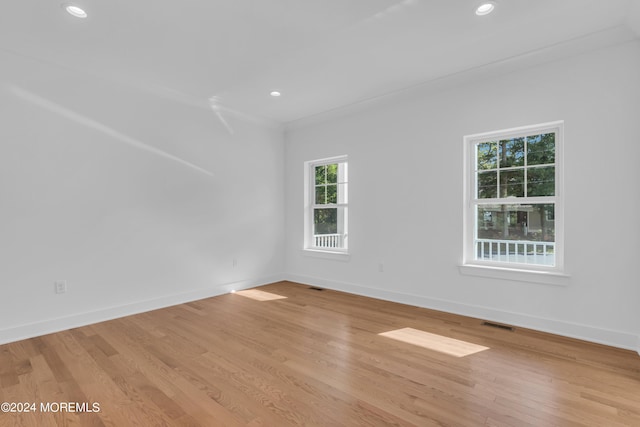 spare room featuring light wood-style floors, baseboards, visible vents, and recessed lighting