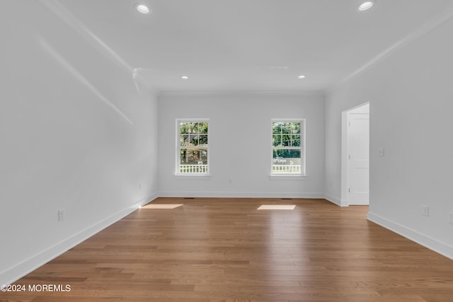 unfurnished room with light wood-type flooring, crown molding, baseboards, and recessed lighting