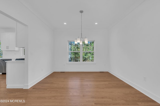 unfurnished dining area featuring recessed lighting, a notable chandelier, light wood-style flooring, and baseboards