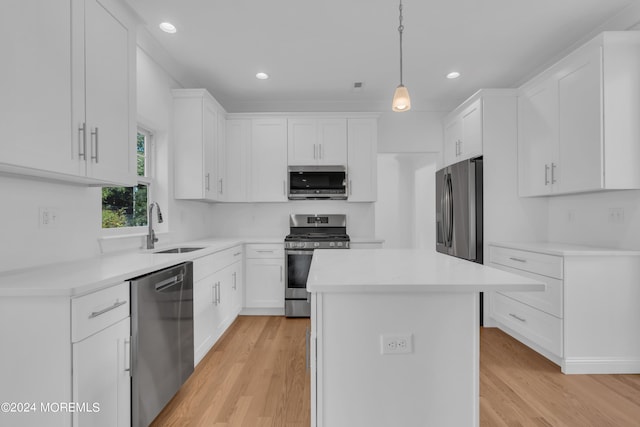 kitchen featuring white cabinets, a kitchen island, stainless steel appliances, and light countertops