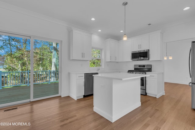 kitchen featuring white cabinets, a kitchen island, decorative light fixtures, stainless steel appliances, and light countertops