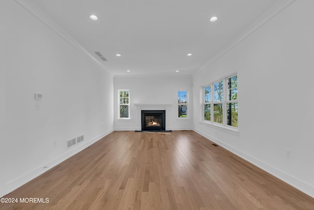 unfurnished living room featuring light wood finished floors, baseboards, and visible vents