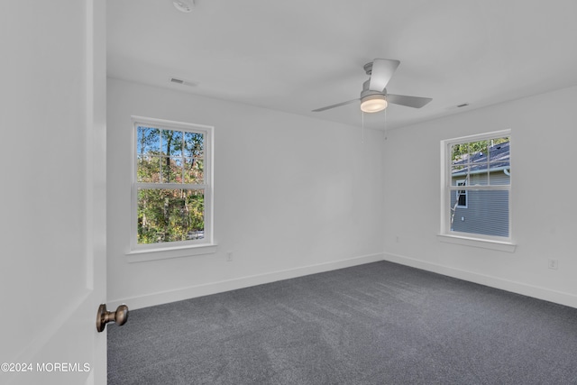 spare room featuring carpet floors, plenty of natural light, baseboards, and a ceiling fan