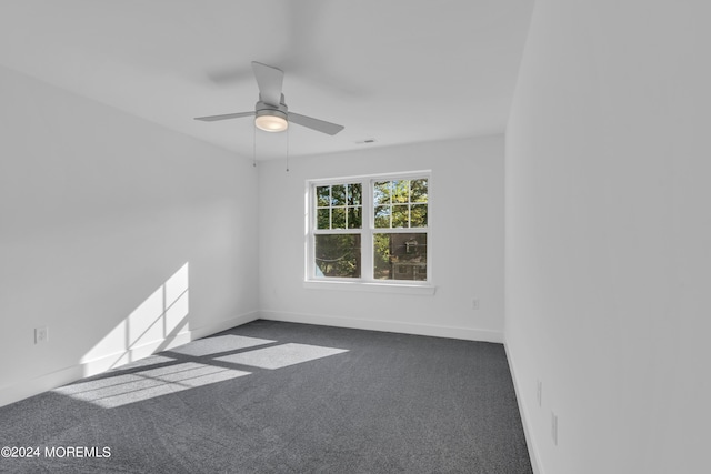 carpeted empty room featuring ceiling fan and baseboards